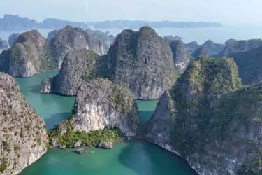 Aerial view of Ha Long Bay, Vietnam, with emerald water and towering limestone karst islands—UNESCO World Heritage seascape cruise scenery.