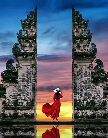 Young woman standing in temple gates at Lempuyang Luhur temple in Bali, Indonesia.