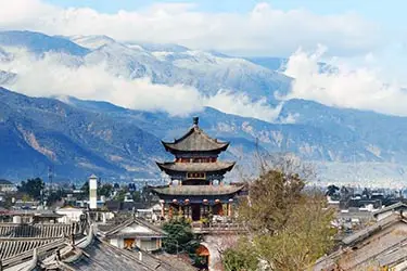 Dali Old Town with traditional Bai architecture and pagoda set against the Cangshan Mountains in Yunnan.