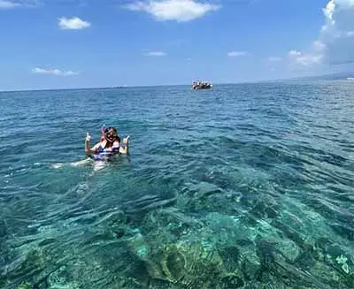 Snorkeler exploring clear turquoise waters off Gili Air, Indonesia, showcasing vibrant marine life and the island’s pristine tropical sea.