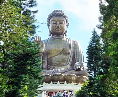 Tian Tan Buddha (Big Buddha) on Lantau Island, Hong Kong, surrounded by lush greenery and visited by pilgrims and travelers.