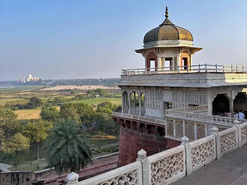 Historic Mughal balcony at Agra Fort facing the Taj Mahal across the Yamuna River plain
