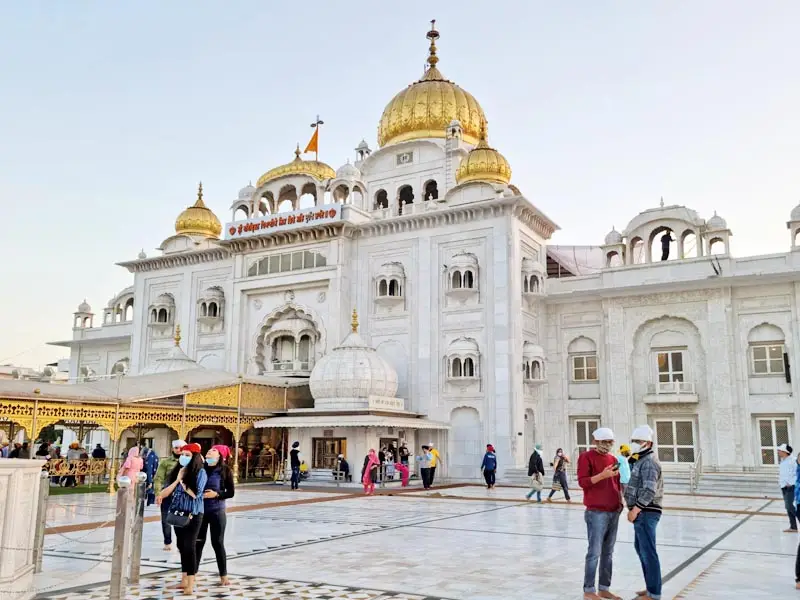 Devotees visiting the golden-domed Gurudwara Bangla Sahib in New Delhi, a major Sikh pilgrimage site known for its white marble architecture.