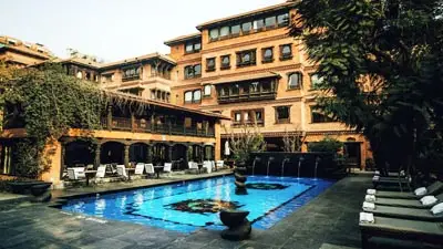 Courtyard pool at Dwarika’s Hotel in Thimphu, Bhutan, featuring traditional wood-carved architecture, stone paving, and a serene outdoor swimming pool surrounded by lounge chairs.