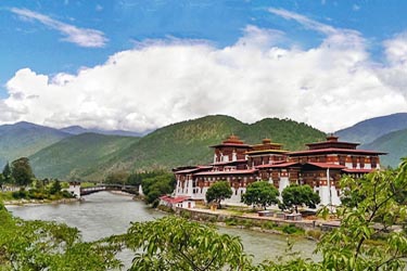 Punakha Dzong at the confluence of the Pho Chhu and Mo Chhu rivers, framed by forested hills in central Bhutan