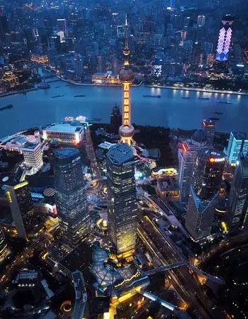 Shanghai skyline at night with the Oriental Pearl Tower overlooking the Huangpu River, showcasing Pudong’s modern cityscape.