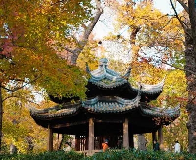 Classical garden pavilion in Suzhou surrounded by autumn foliage, showcasing the city’s renowned landscape design and traditional architecture.