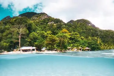 Tropical shoreline on Gili Air, Indonesia, featuring turquoise waters, lush green hills, and a relaxed island atmosphere along the Lombok coast.