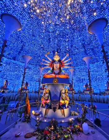 Vibrant Durga Puja pandal adorned with blue decorative lights and a grand idol o