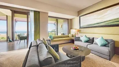Spacious ocean-view suite at Shangri-La Rasa Ria in Kota Kinabalu, Malaysia, featuring modern seating area and private balcony overlooking the beach