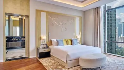 Elegant guest room at Pavilion Hotel by Banyan Tree in Kuala Lumpur, Malaysia, featuring floor-to-ceiling windows with city skyline views