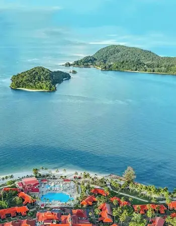 Aerial view of tropical coastline and resort in Langkawi, highlighting a serene island escape surrounded by emerald waters and forested hills