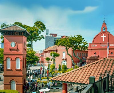 Historic Dutch Square in Malacca, Malaysia, featuring the red Christ Church and colonial-era clock tower in the UNESCO-listed city center