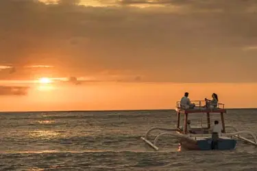 Traditional fishing boat at sunset in Jimbaran Bay, Bali, capturing the golden light and tranquil coastal atmosphere along Indonesia’s scenic shoreline.
