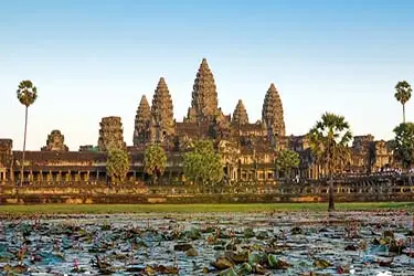 Angkor Wat temple at sunrise in Siem Reap, Cambodia, reflected across a lotus-filled pond—iconic Khmer architecture and UNESCO World Heritage Site in the Angkor Archaeological Park.