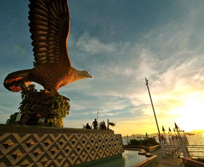 Langkawi Eagle Square (Dataran Lang) at sunset in Langkawi, Malaysia, featuring the iconic eagle statue overlooking the waterfront and Andaman Sea