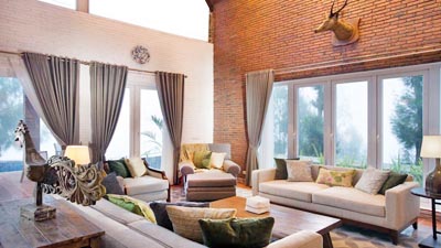Spacious living area at Plataran Bromo in East Java, Indonesia, featuring warm brick interiors and panoramic highland views near Mount Bromo.