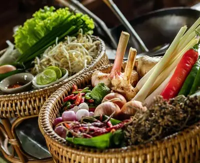 Balinese cooking class ingredients including lemongrass, chilies, garlic, fresh herbs, and vegetables arranged in woven baskets for a traditional hands-on culinary experience in Bali.