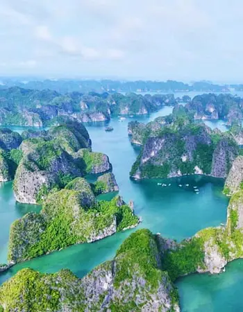 Aerial panorama of Ha Long Bay, Vietnam, with emerald waters winding between lush limestone karsts, showcasing one of Southeast Asia’s most iconic UNESCO-listed seascapes.