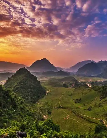 Sunrise over the lush valleys and limestone mountains of Mai Chau, Vietnam, revealing peaceful rural landscapes and the region’s natural beauty.