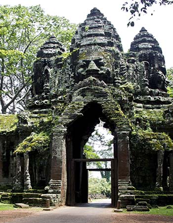 South Gate of Angkor Thom in Cambodia, featuring towering stone faces and ancient Khmer carvings framed by jungle greenery.