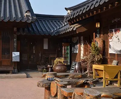 Traditional hanok courtyard with wooden architecture and tiled roofs in Bukchon Hanok Village, Seoul, South Korea, home to historic homes, cafés, and cultural shops.