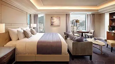 Spacious luxury guest room at Lotte Hotel Seoul featuring modern furnishings, king bed, and city views in central Seoul, South Korea.